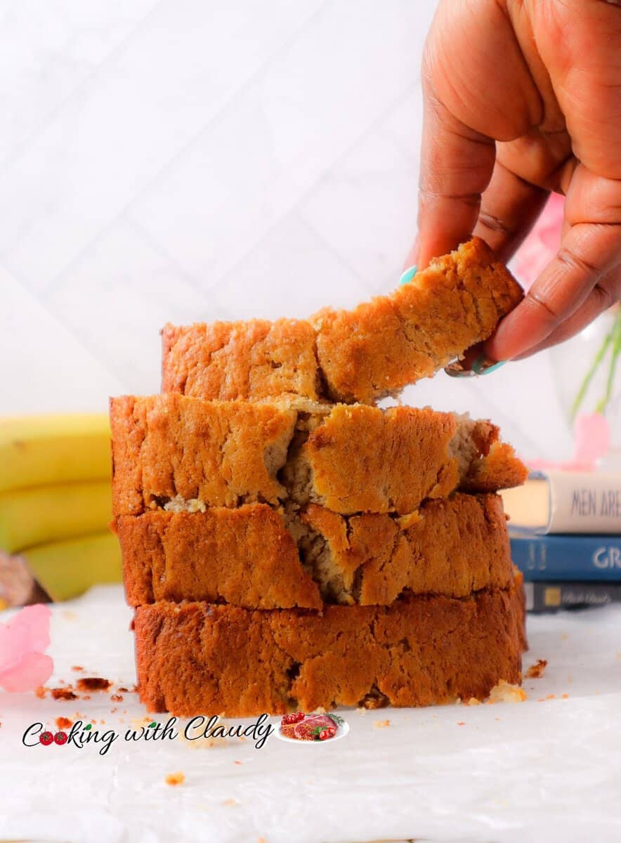 Person taking a slice of Banana Bread with Sour Cream from a stack.