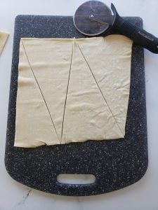 Puff pastry dough that has been cut into triangles.