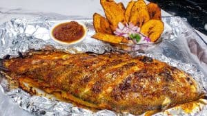 Grilled whole fish on a sheet of aluminum foil.