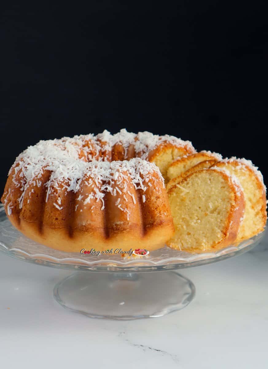 Partially-sliced Coconut Cake on a raised platter.