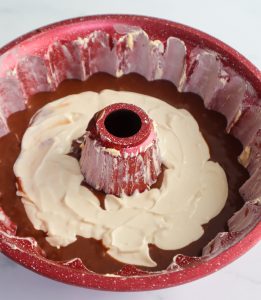 Circle of cream cheese batter in chocolate batter in a bundt pan.