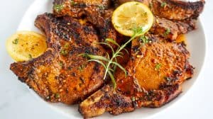 Baked Herbed Pork Chops with Garlic Butter on a white plate.