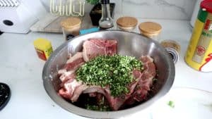 Pork chops topped with garlic and herbs in a bowl.