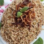 Oblong dish piled high with Mujadara (Lentils and Rice.)