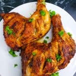 Two chicken legs on a white plate.