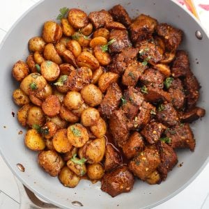 Garlic Butter Steak Bites and Potatoes in a skillet.