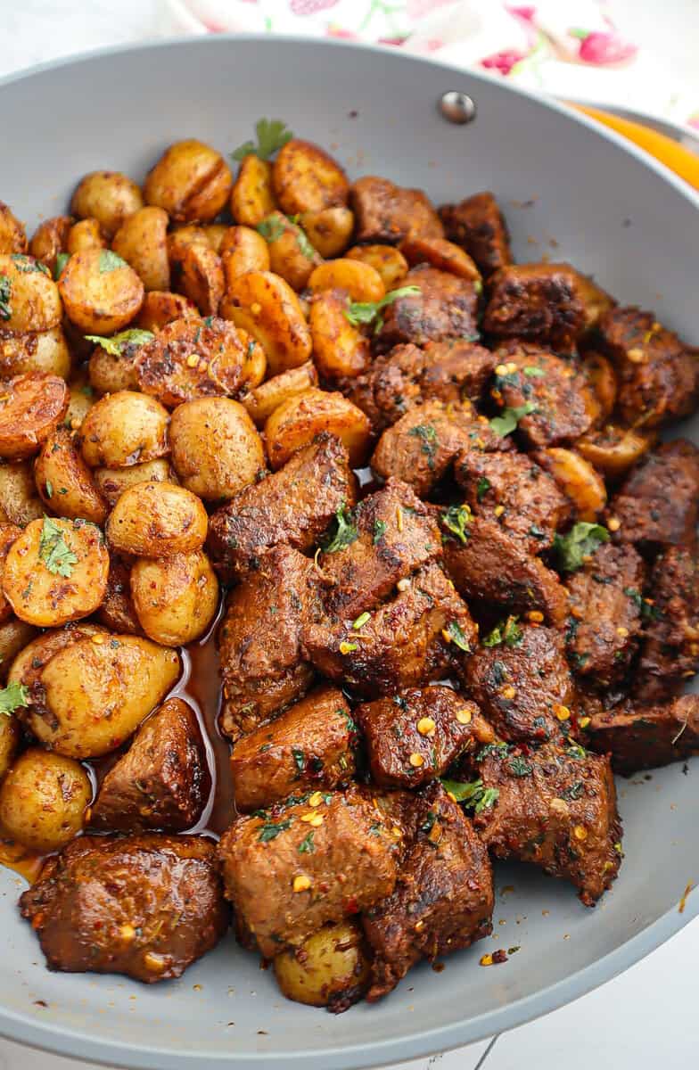 Skillet of Garlic Butter Steak Bites and Potatoes.