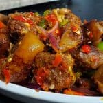 Asun (Spicy, Smoked Goatmeat) piled in a bowl.