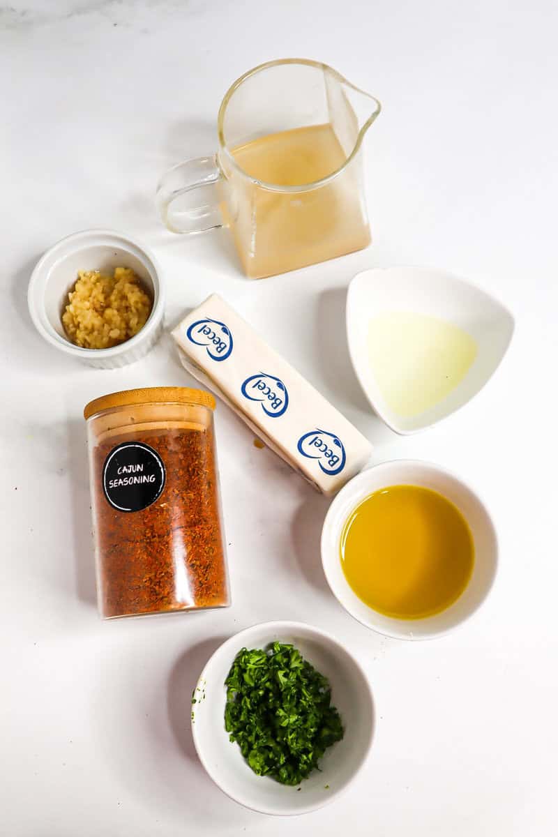 Cajun Butter Sauce ingredients including butter, parsley, and broth.