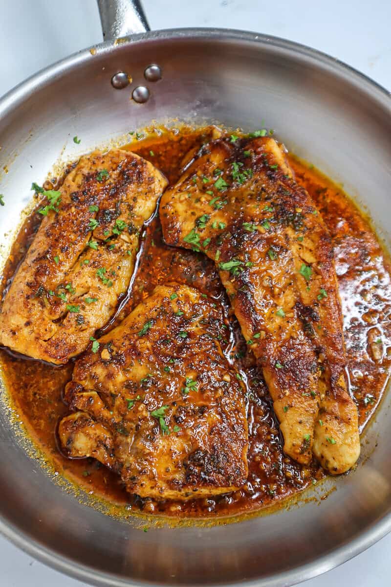 Pan of Pan-Seared Cajun Red Snapper with Cajun Butter Sauce.