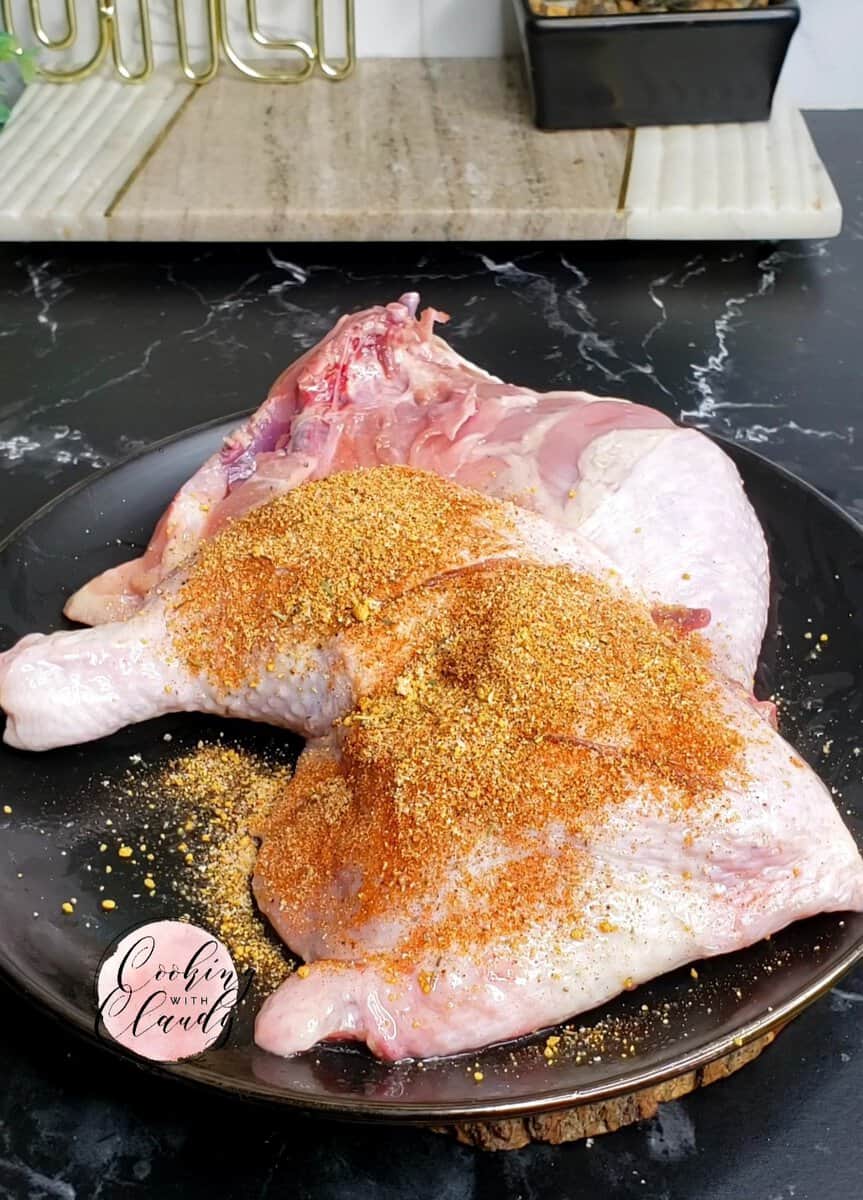 Dry rub piled on chicken legs.