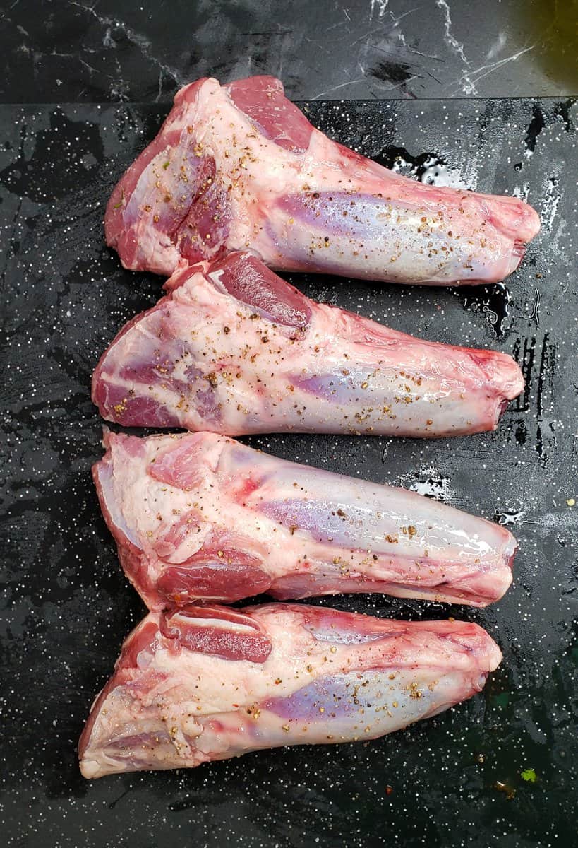 Lamb Shanks seasoned with salt and pepper.