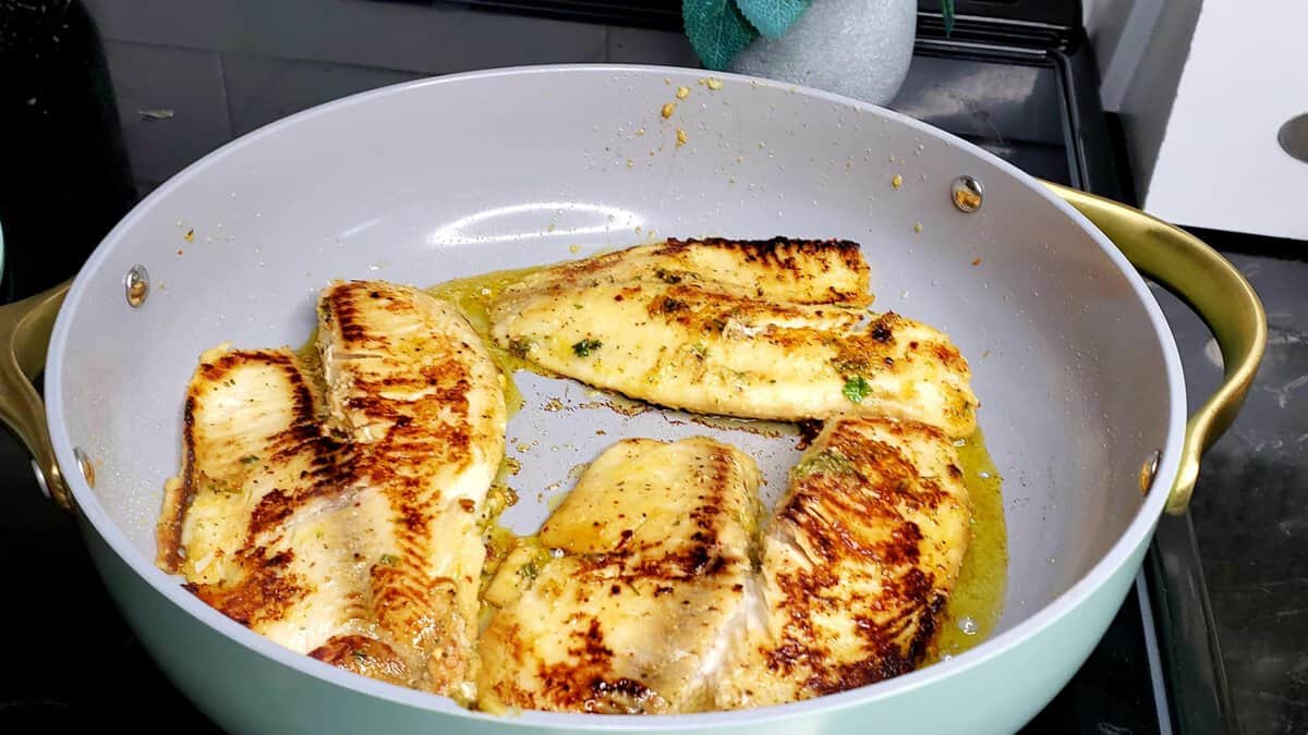 Lemon pepper tilapia in a pan.