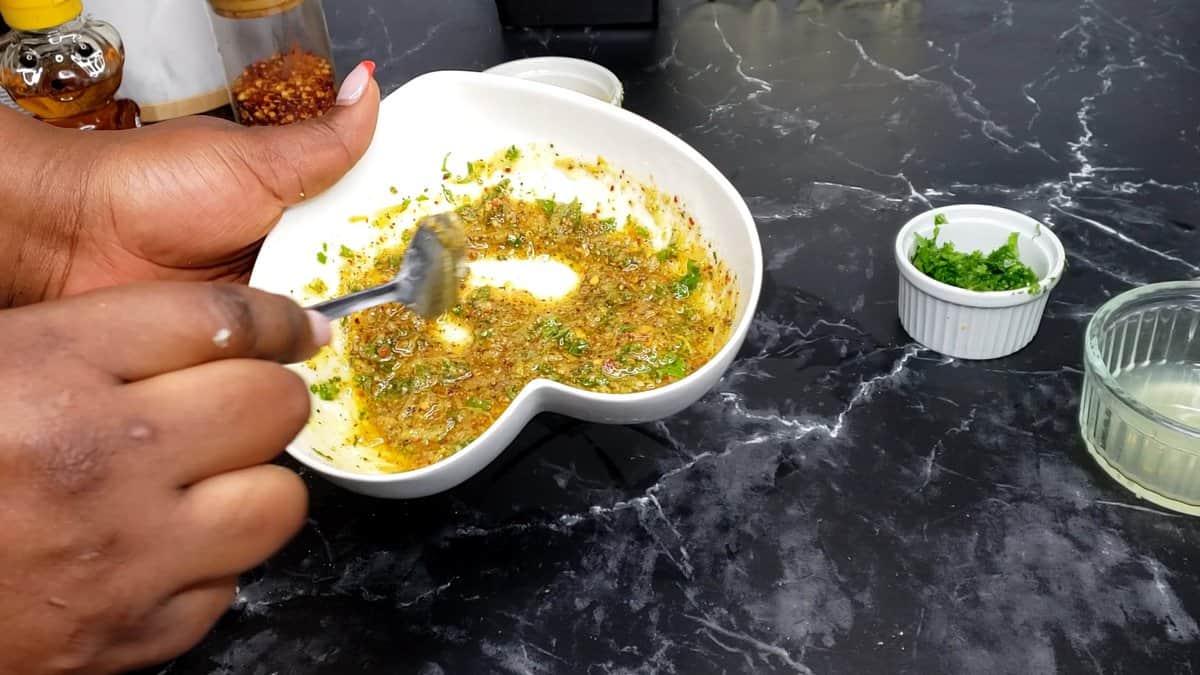 Person stirring a heart-shaped bowl of marinade.