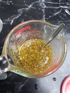 Spoon in a measuring cup of marinade.