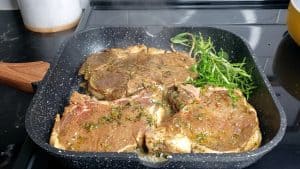 Marinated pork chops in a grill pan.