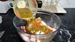 Marinade pouring over pork chops in a bowl.