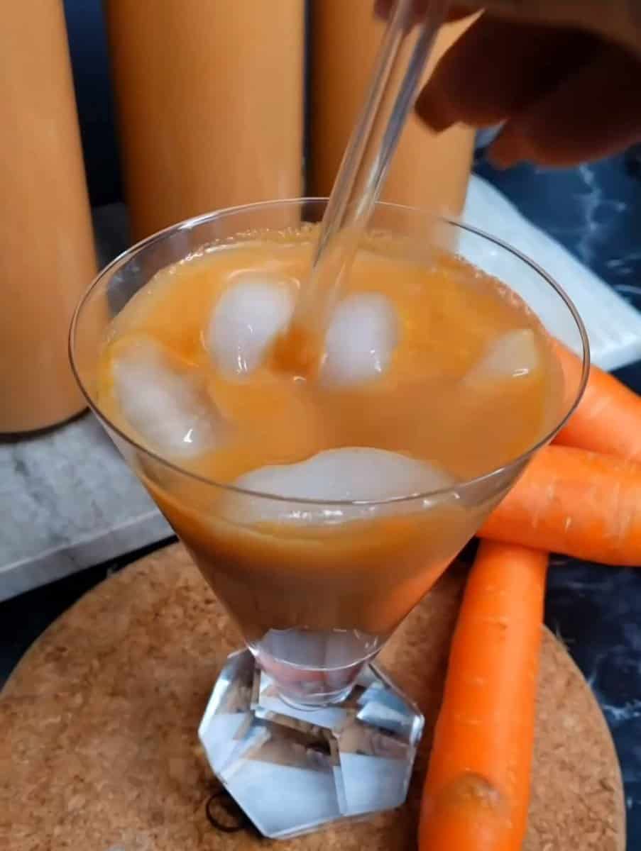 Ice floating in a glass of Jamaican Carrot Juice.