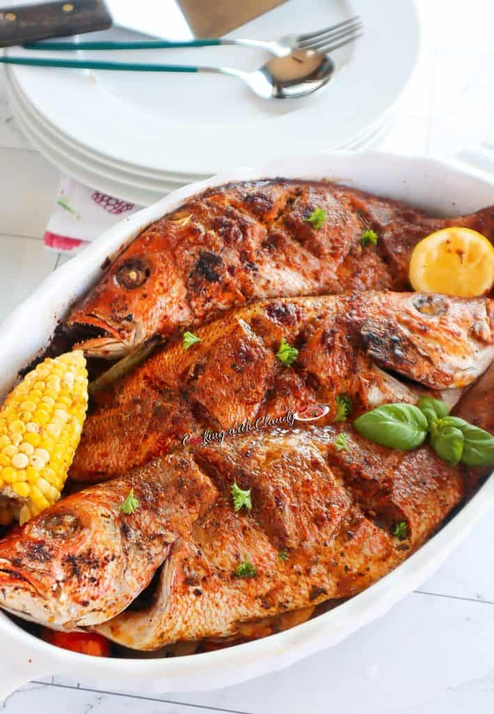Three baked whole red snappers in an oblong dish.