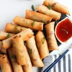 Air Fryer Spring Tolls on a dish with dipping sauce.
