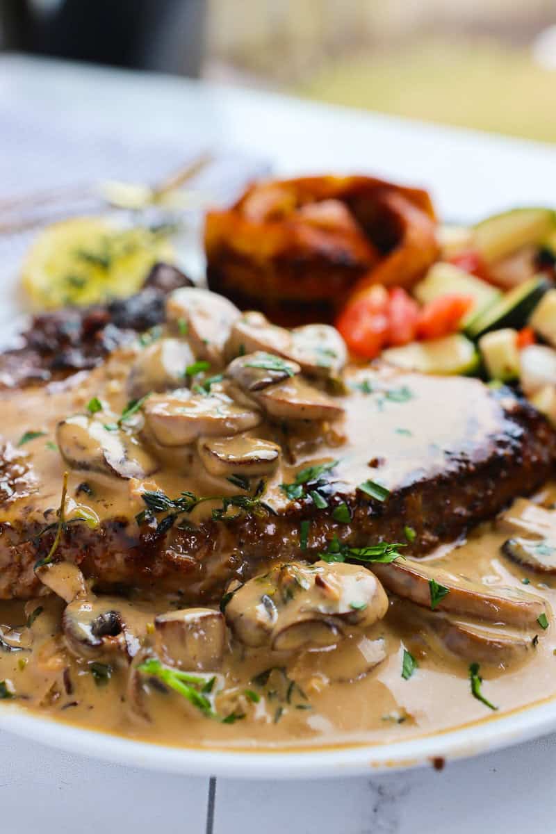 Creamy Mushroom Sauce over a steak on a plate.