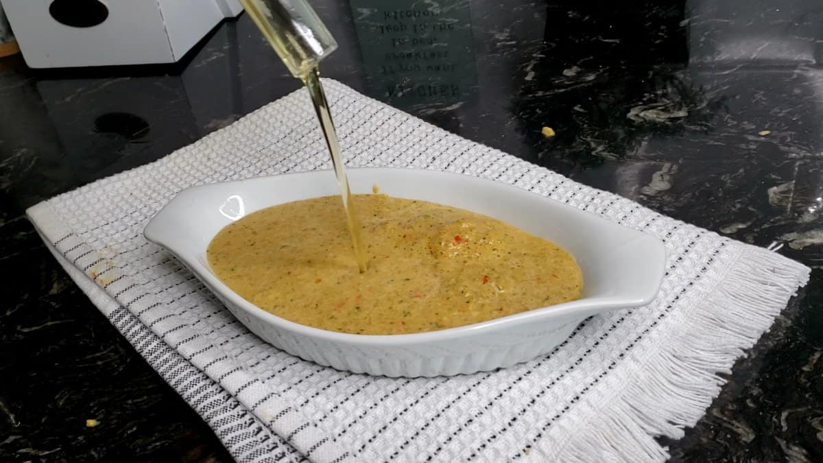 Oil pouring into a bowl of marinade.