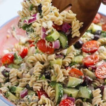 Wooden spoon with a scoop of Mediterranean Pasta Salad.