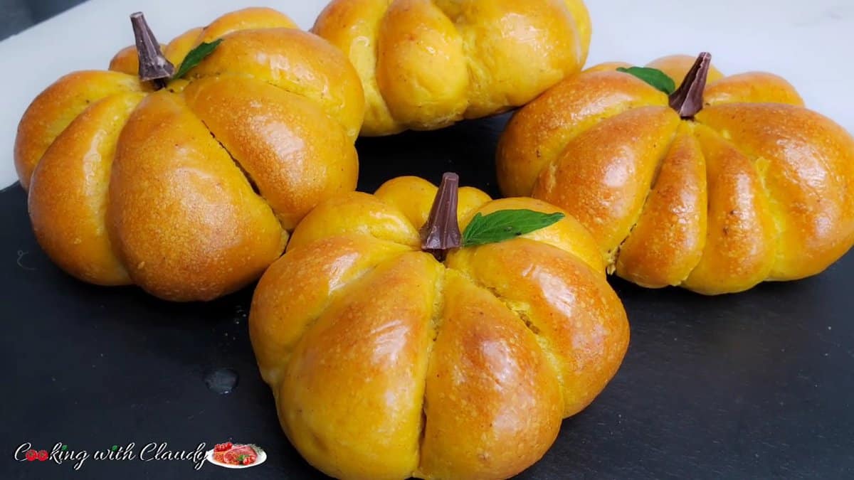 Pumpkin-Shaped Dinner Rolls on a black serving dish.