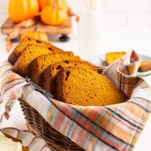 Pumpkin cake loaf slices in basket on a cloth.