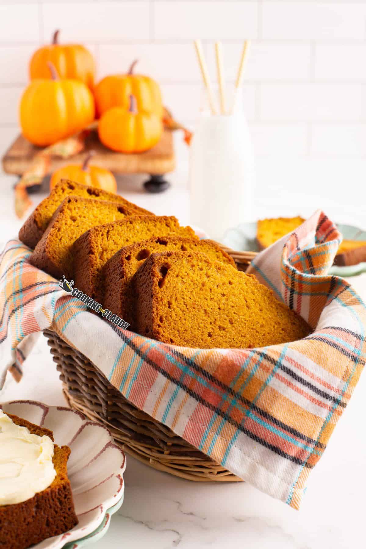 Pumpkin cake loaf slices in basket on a cloth.