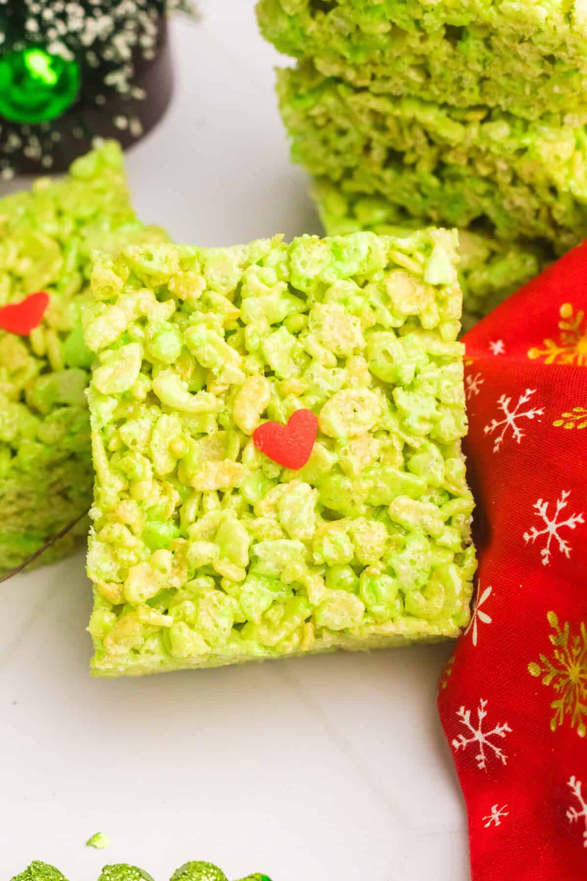 bright green rice Krispie treat with a heart shaped sprinkle in the middle. 