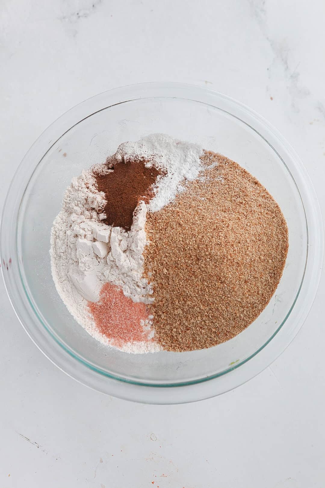 A bowl with brown sugar, flour, baking powder, nutmeg and other spices. 