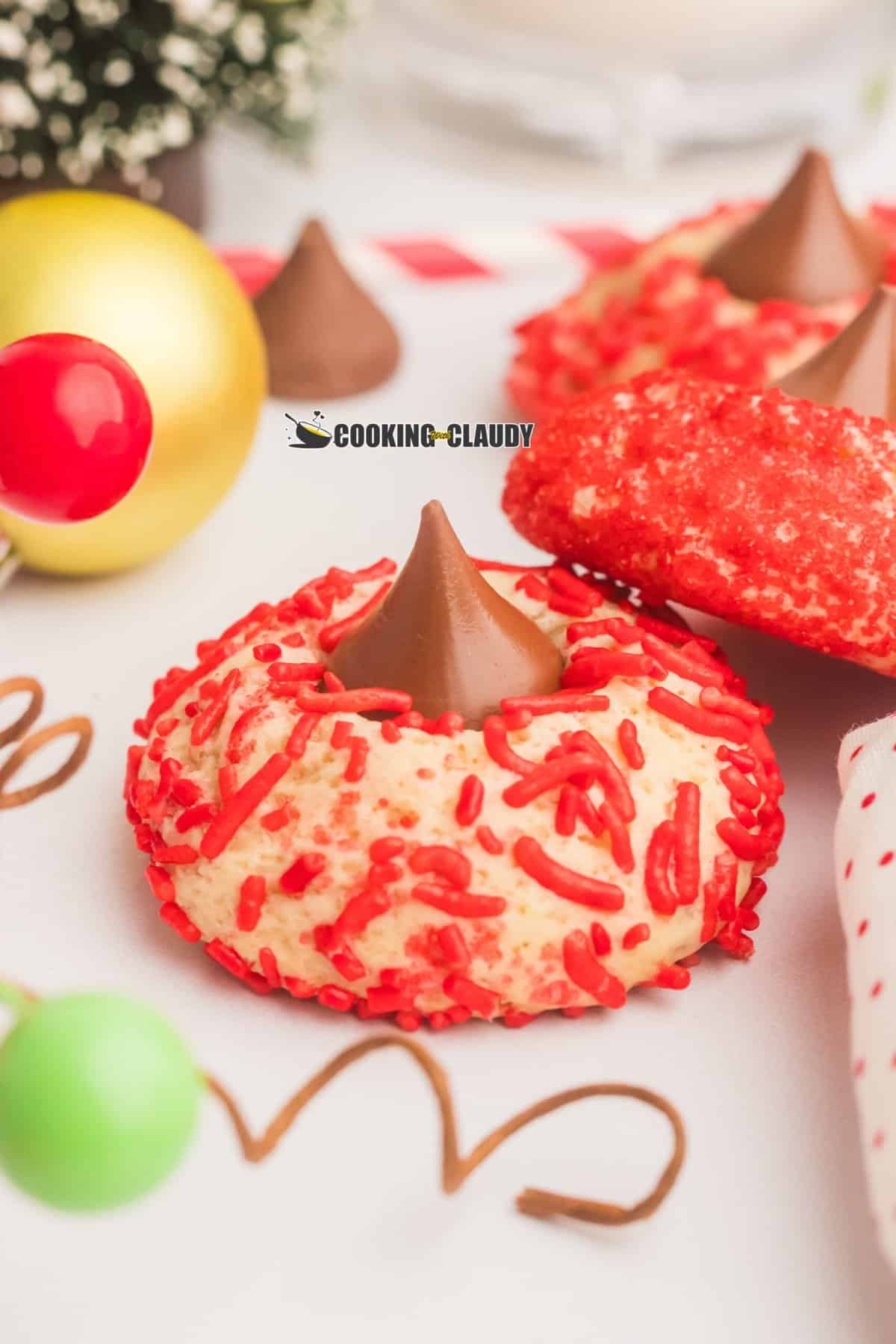 Christmas Blossom cookies with red sprinkles and a Hershey's Kiss in the middle. 