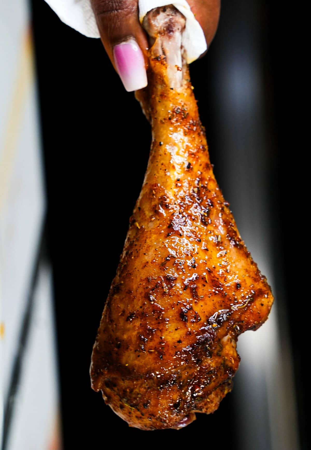 hand holding a baked turkey wing