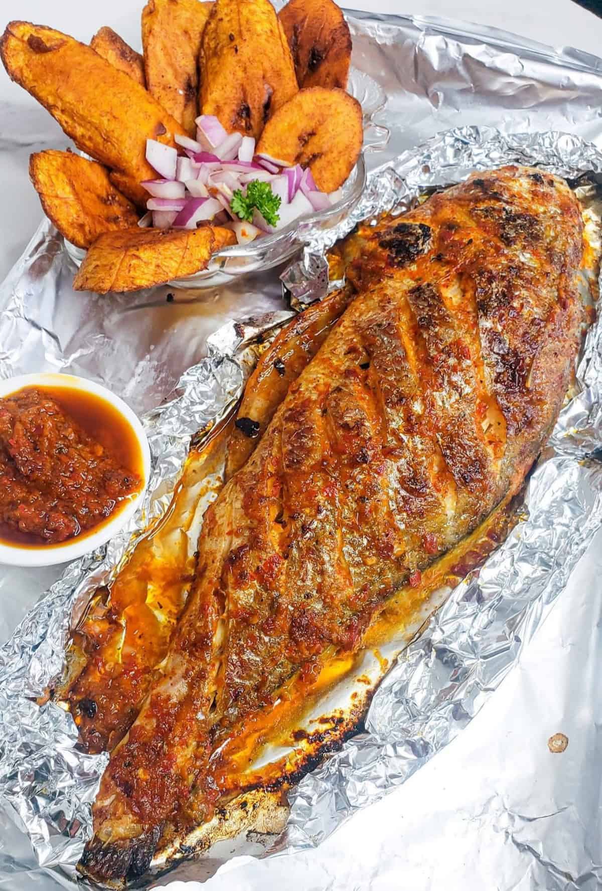 grilled whole fish in foil with sauce