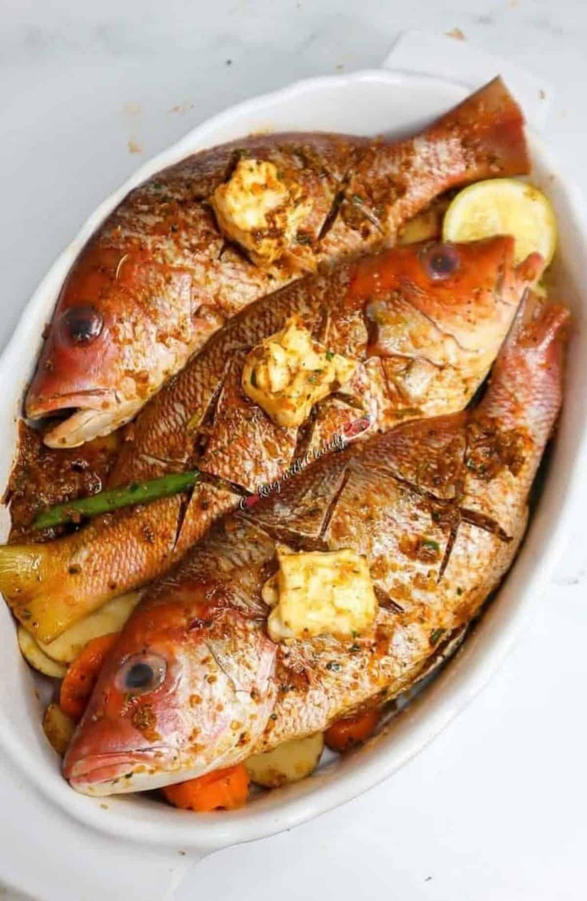 oven baked red snapper in a bowl with butter