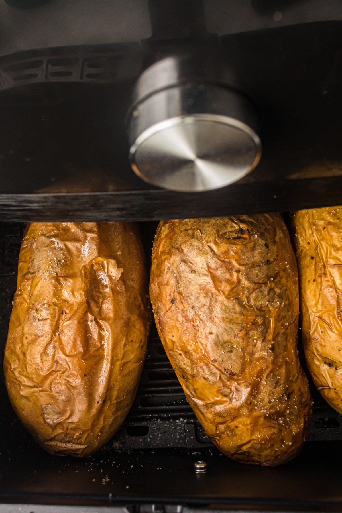air fryer baked potatoes in an air fryer basket