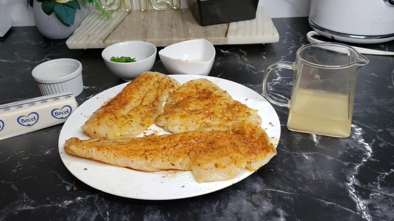 red snapper fillets in a pan seasoned with cajun