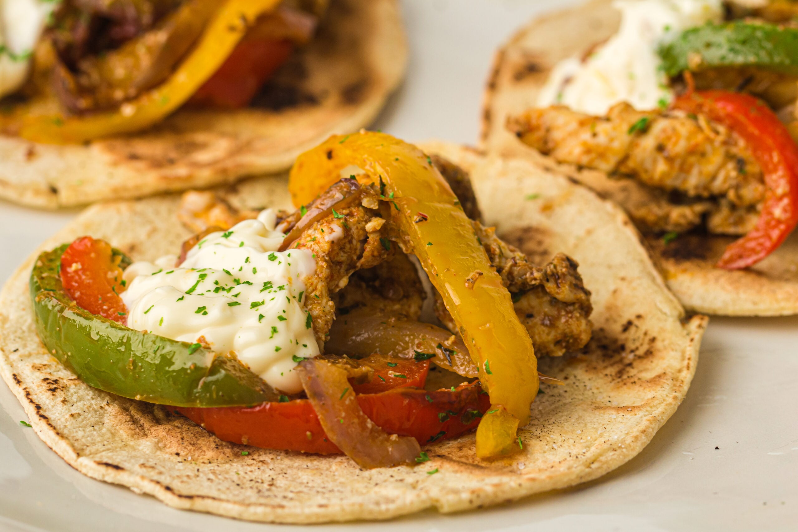 Close-up of juicy air fryer chicken fajita strips with charred peppers and onions