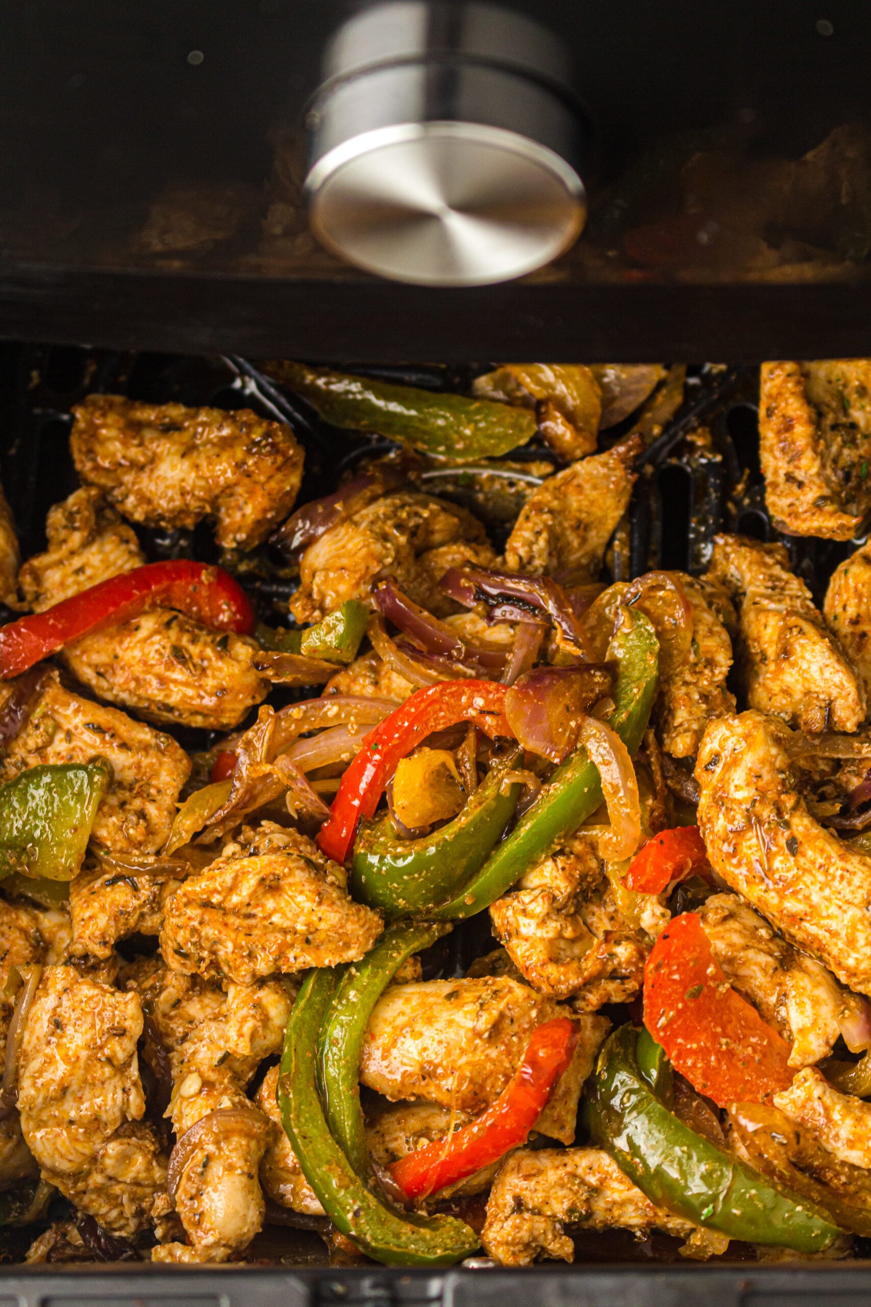 Finished air fryer chicken fajitas with golden, lightly charred edges