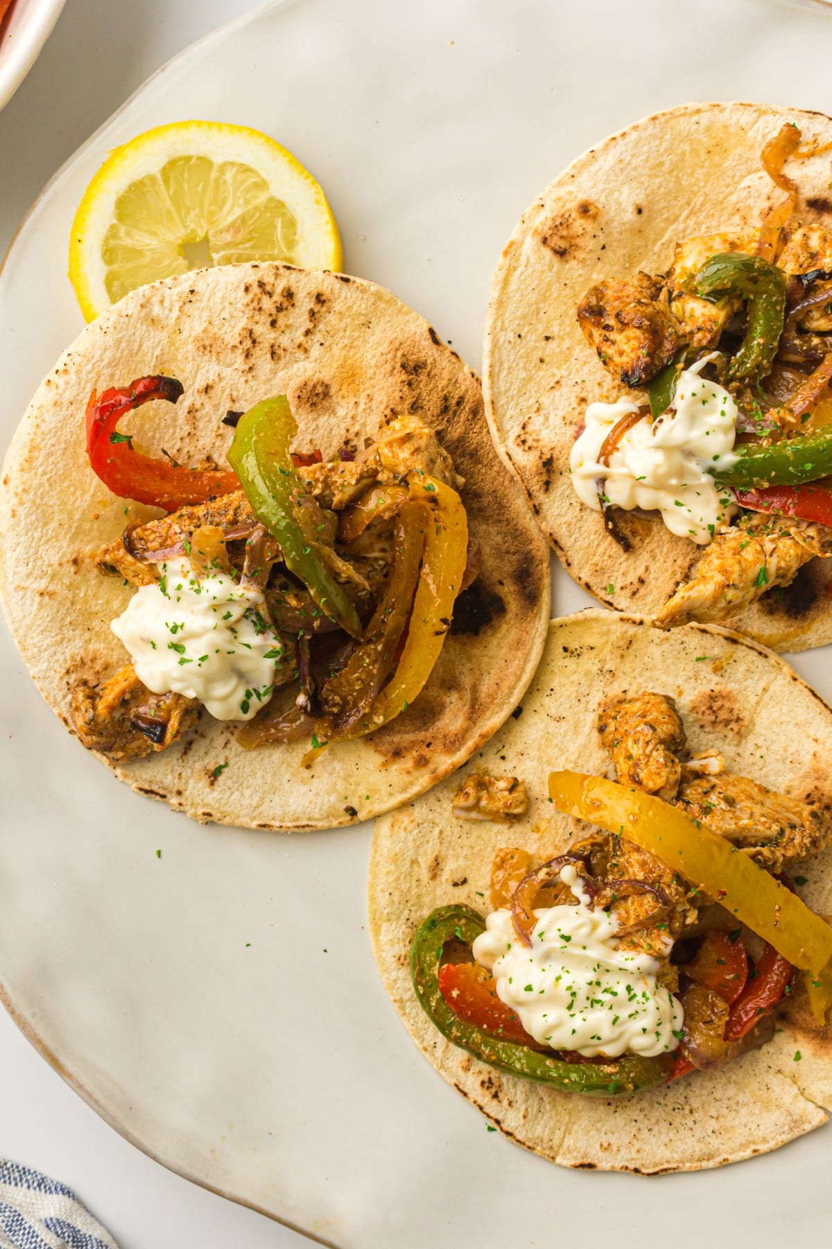 Air fryer chicken fajitas with charred bell peppers and onions served in warm flour tortillas